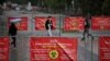 KAZAKHSTAN -- People walk past banners informing of preventive measures against the coronavirus disease (COVID-19) in Almaty, May 20, 2021